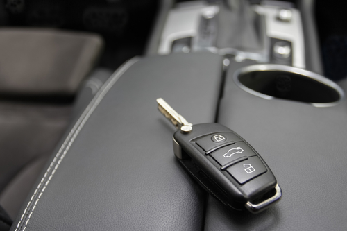 car key to a German luxury car, the key is lying on dark leather.